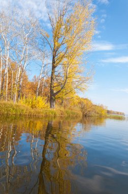 Sonbahar, sudaki ağaçların göldeki yansıması üzerine sessizdir.