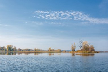 Sonbahar, sudaki ağaçların göldeki yansıması üzerine sessizdir.
