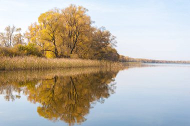 Sonbahar, sudaki ağaçların göldeki yansıması üzerine sessizdir.