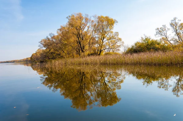Sonbahar, sudaki ağaçların göldeki yansıması üzerine sessizdir.