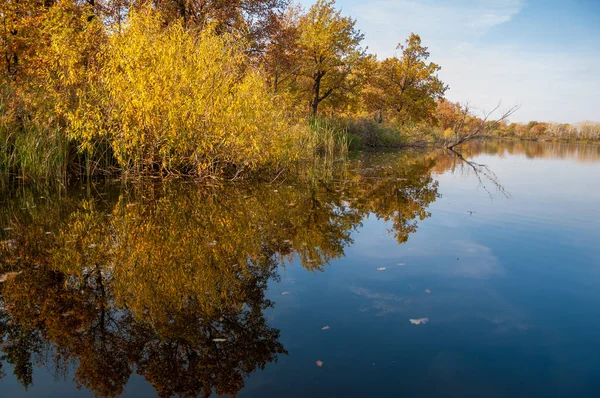 Sonbahar, sudaki ağaçların göldeki yansıması üzerine sessizdir.