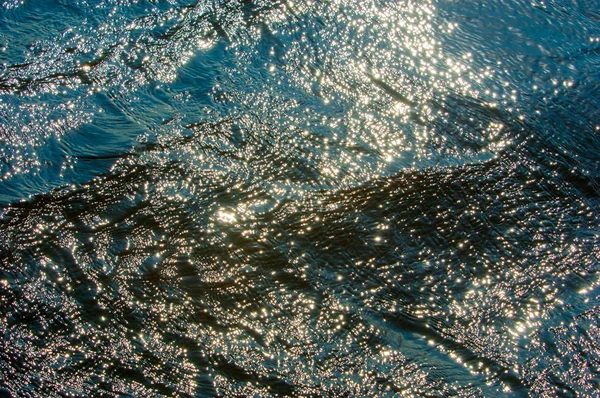 Textura. antecedentes. água sob o sol poente — Fotografia de Stock