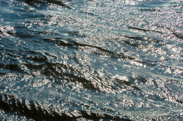 Textura. antecedentes. água sob o sol poente — Fotografia de Stock
