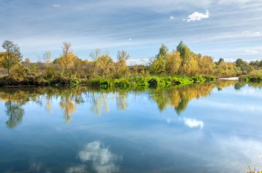 Sonbahar, nehrin ormanı ile kaplı parlak güneşli bir günde