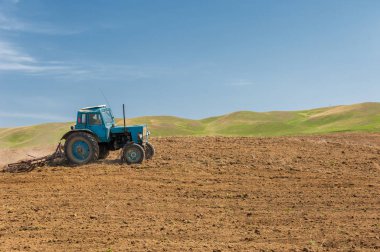 Kazakistan 'da tarımsal işlemler, toprak ekimi. Çiftçilik sırasında ağır traktörleri sürmek tarlada sabanla çalışır.