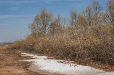 Bahar manzarası. Bahar tarlasındaki son kar. tepelik terra