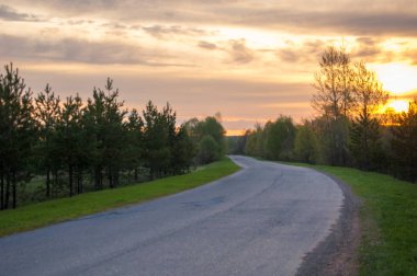 Bahar manzarası, gün doğumu. Bir köy yolu, kırsal bir arazi.