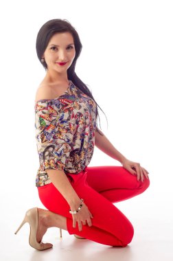 Güzel kız, kırmızı pantolon, yüksek topuklu bej ayakkabılar, izole edilmiş.