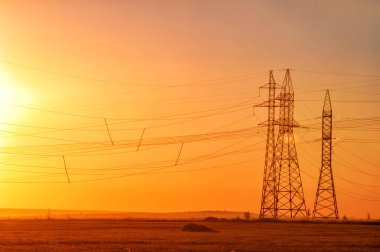 Yüksek gerilim enerji nakil hattı. Enerji ayağı. Gün batımında,