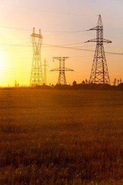 Yüksek gerilim enerji nakil hattı. Enerji ayağı. Gün batımında,