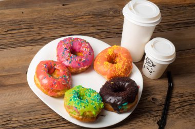 Çok renkli jöleli çörekler. Beyaz bir tabakta, tahta tahtalarda.