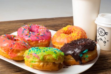 Çok renkli jöleli çörekler. Beyaz bir tabakta, tahta tahtalarda.