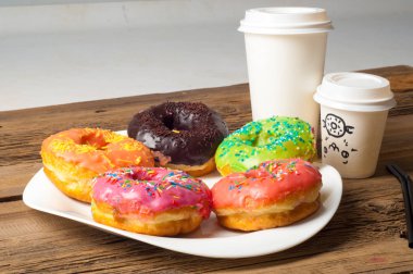 Çok renkli jöleli çörekler. Beyaz bir tabakta, tahta tahtalarda.