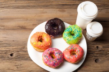 Çok renkli jöleli çörekler. Beyaz bir tabakta, tahta tahtalarda.