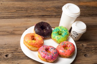 Çok renkli jöleli çörekler. Beyaz bir tabakta, tahta tahtalarda.