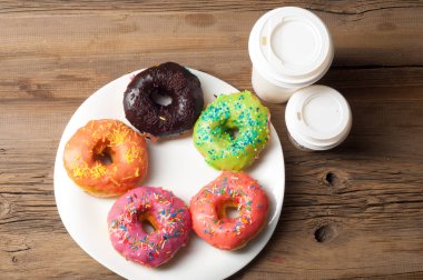 Çok renkli jöleli çörekler. Beyaz bir tabakta, tahta tahtalarda.