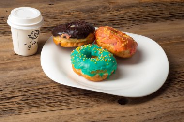 Çok renkli jöleli çörekler. Beyaz bir tabakta, tahta tahtalarda.