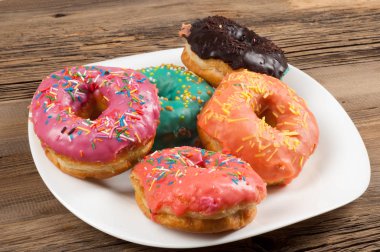 Çok renkli jöleli çörekler. Beyaz bir tabakta, tahta tahtalarda.