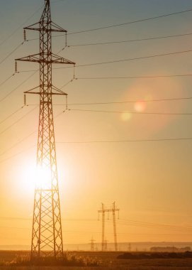 Yüksek gerilim enerji nakil hattı. Enerji ayağı. Gün batımında,
