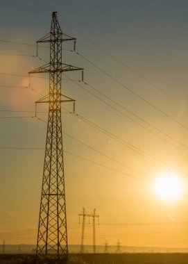 Yüksek gerilim enerji nakil hattı. Enerji ayağı. Gün batımında,