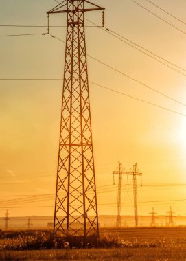 Yüksek gerilim enerji nakil hattı. Enerji ayağı. Gün batımında,