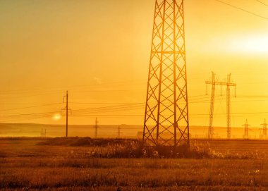 Yüksek gerilim enerji nakil hattı. Enerji ayağı. Gün batımında,