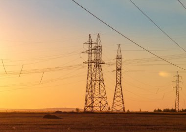Yüksek gerilim enerji nakil hattı. Enerji ayağı. Gün batımında,