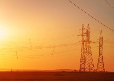 Yüksek gerilim enerji nakil hattı. Enerji ayağı. Gün batımında,
