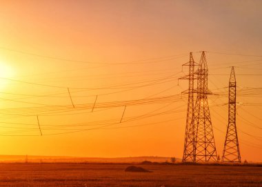 Yüksek gerilim enerji nakil hattı. Enerji ayağı. Gün batımında,