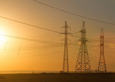 Yüksek gerilim enerji nakil hattı. Enerji ayağı. Gün batımında,
