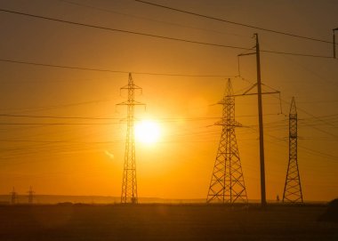 Yüksek gerilim enerji nakil hattı. Enerji ayağı. Gün batımında,