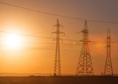 Yüksek gerilim enerji nakil hattı. Enerji ayağı. Gün batımında,