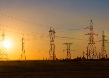 Yüksek gerilim enerji nakil hattı. Enerji ayağı. Gün batımında,