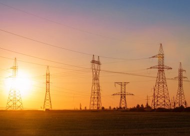 Yüksek gerilim enerji nakil hattı. Enerji ayağı. Gün batımında,