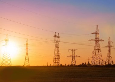 Yüksek gerilim enerji nakil hattı. Enerji ayağı. Gün batımında,