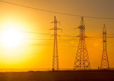 Yüksek gerilim enerji nakil hattı. Enerji ayağı. Gün batımında,
