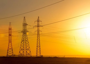 Yüksek gerilim enerji nakil hattı. Enerji ayağı. Gün batımında,
