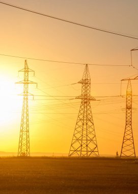 Yüksek gerilim enerji nakil hattı. Enerji ayağı. Gün batımında,