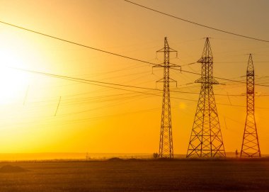 Yüksek gerilim enerji nakil hattı. Enerji ayağı. Gün batımında,