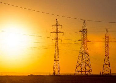 Yüksek gerilim enerji nakil hattı. Enerji ayağı. Gün batımında,