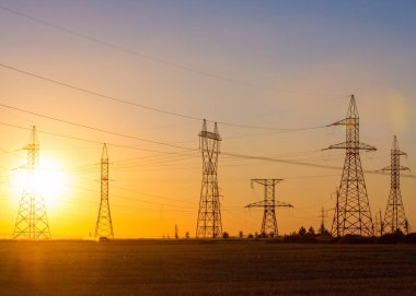 Yüksek gerilim enerji nakil hattı. Enerji ayağı. Gün batımında,