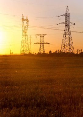Yüksek gerilim enerji nakil hattı. Enerji ayağı. Gün batımında,