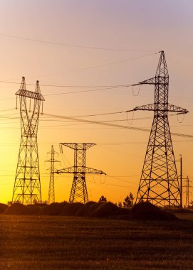 Yüksek gerilim enerji nakil hattı. Enerji ayağı. Gün batımında,