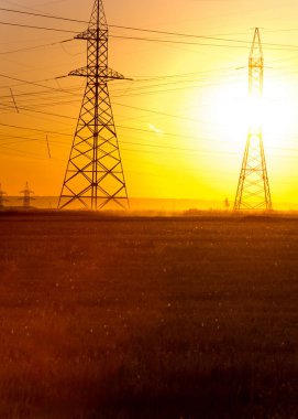Yüksek gerilim enerji nakil hattı. Enerji ayağı. Gün batımında,