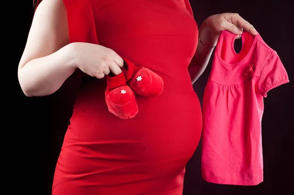 Κόκκινο φόρεμα για την κοιλιά. Έγκυος. βρεφικά ρούχα — Φωτογραφία Αρχείου