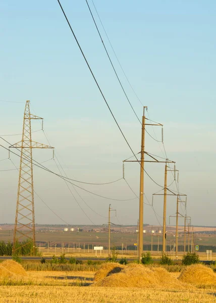 High-voltage power transmission line. Energy pillars. At sunset, — Stock Photo, Image