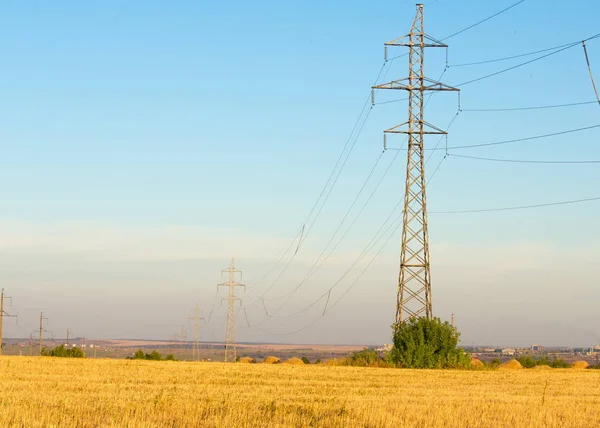 High-voltage power transmission line. Energy pillars. At sunset, — Stock Photo, Image
