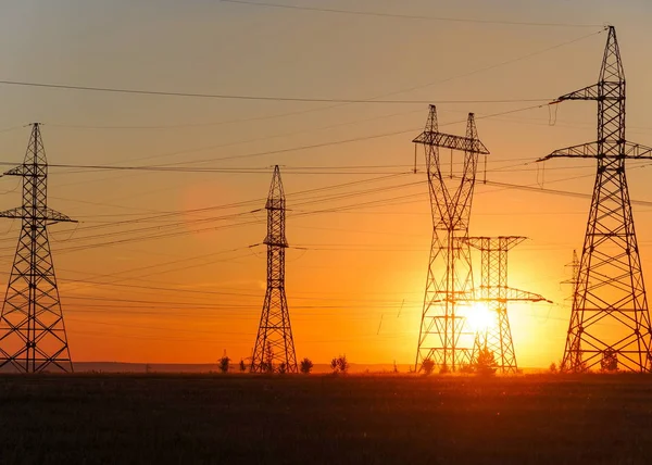 High-voltage power transmission line. Energy pillars. At sunset,