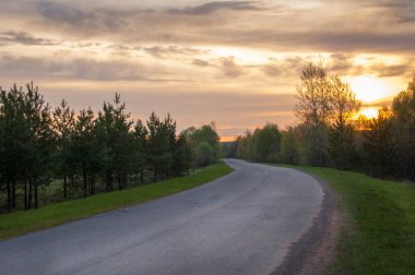 Bahar manzarası, gün doğumu. Bir köy yolu, kırsal bir arazi.