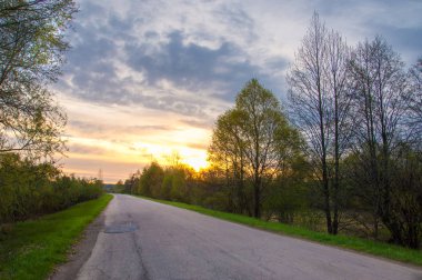 Bahar manzarası, gün doğumu. Bir köy yolu, kırsal bir arazi.